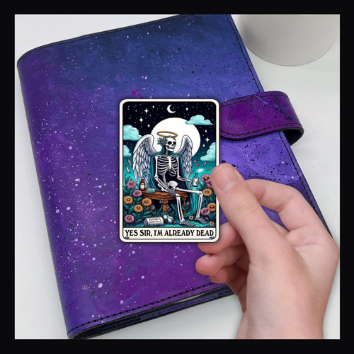 Alternative Tarot Die Cut - I'm already dead shown on a purple planner. 