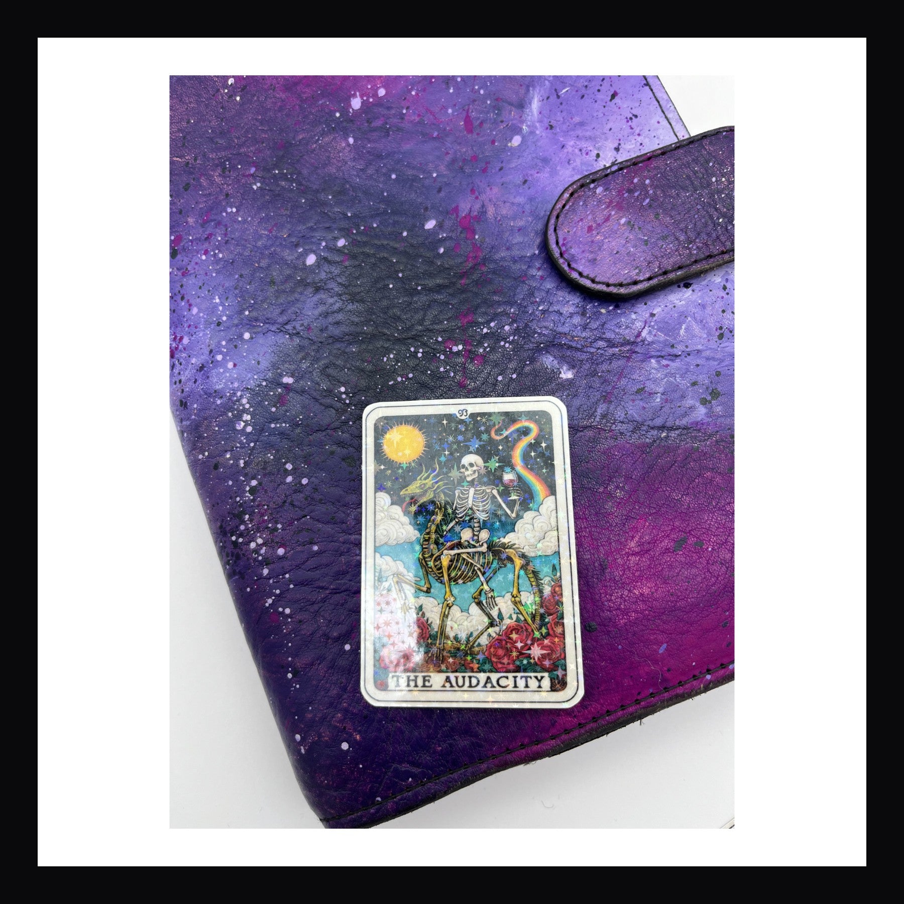 Alternative Tarot Die Cuts - The Audacity is a holographic die cut sticker featuring a skeleton  sitting on a skeletal horse, holding a cup of wine with rainbows in the background.