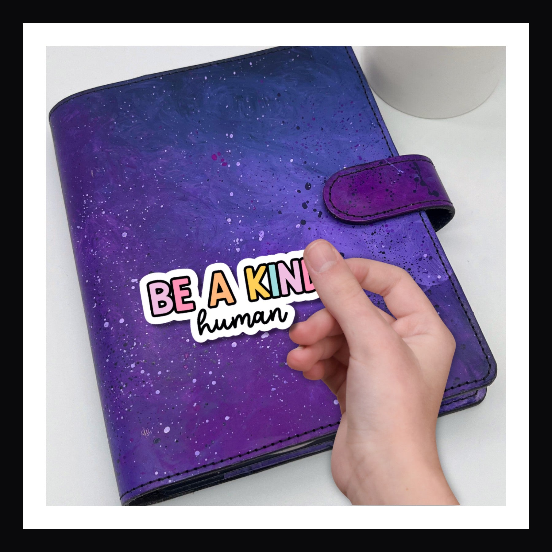 Be A Kind Human Die Cut Sticker shown on a purple planner.