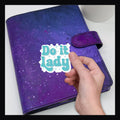 Do It Lady Die Cut, shown on a purple planner. 