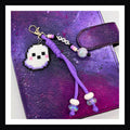 Boo Ghost Charm features a friendly ghost made of fuse beads paired with a purple braided paracord and friendship bracelet style tag that reads "boo". Secured with lobster clasp.