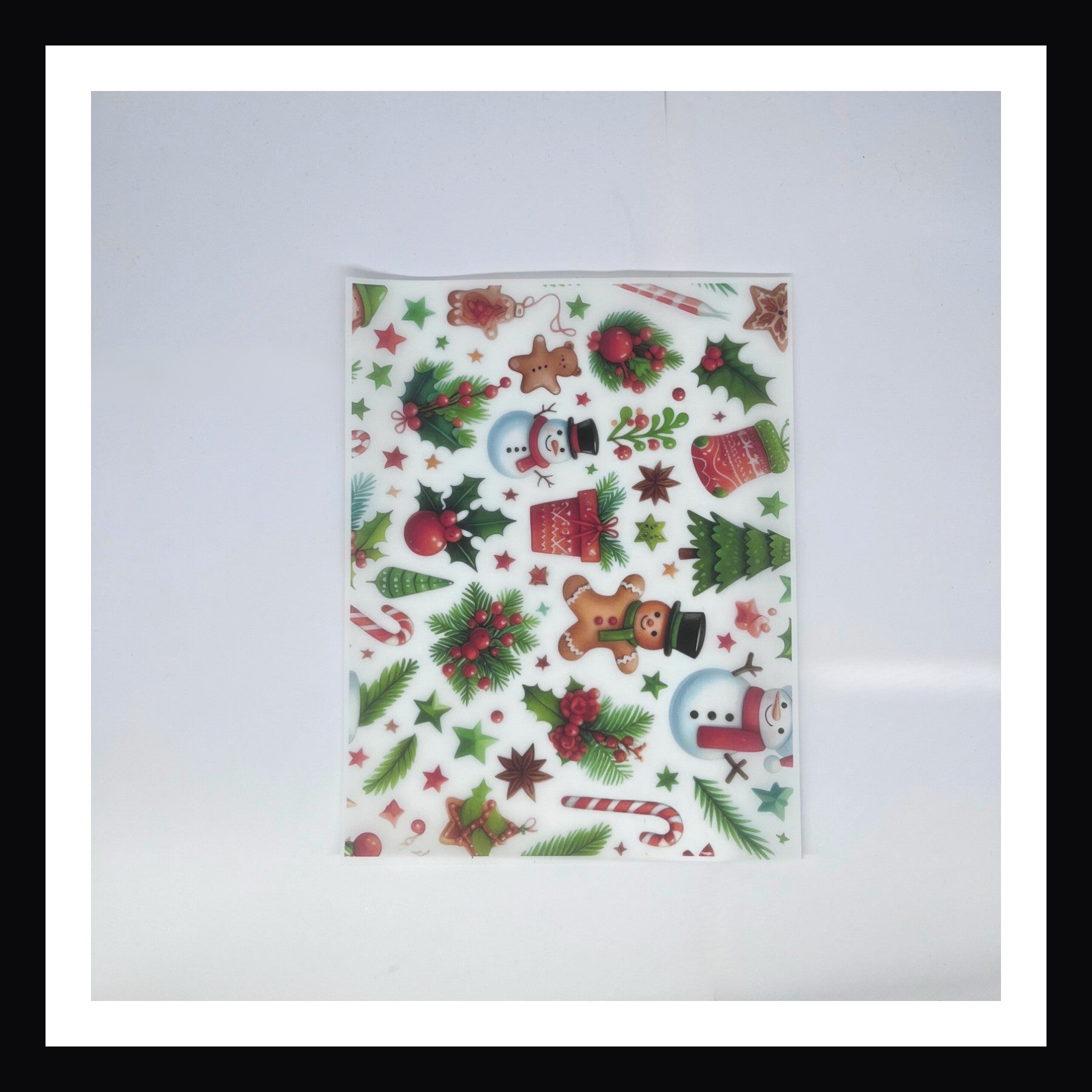Christmas Morning Vellum - Holly Jolly Mix is a 8x10 sheet of printed vellum.  This vellum features a collection of traditional Christmas imagery including snowmen, gingerbread men, candy canes, holly and more.