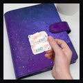 I've Survived Die Cut Sticker reads "I've survived too many storms to be bothered by raindrops".  Shown on a purple planner.