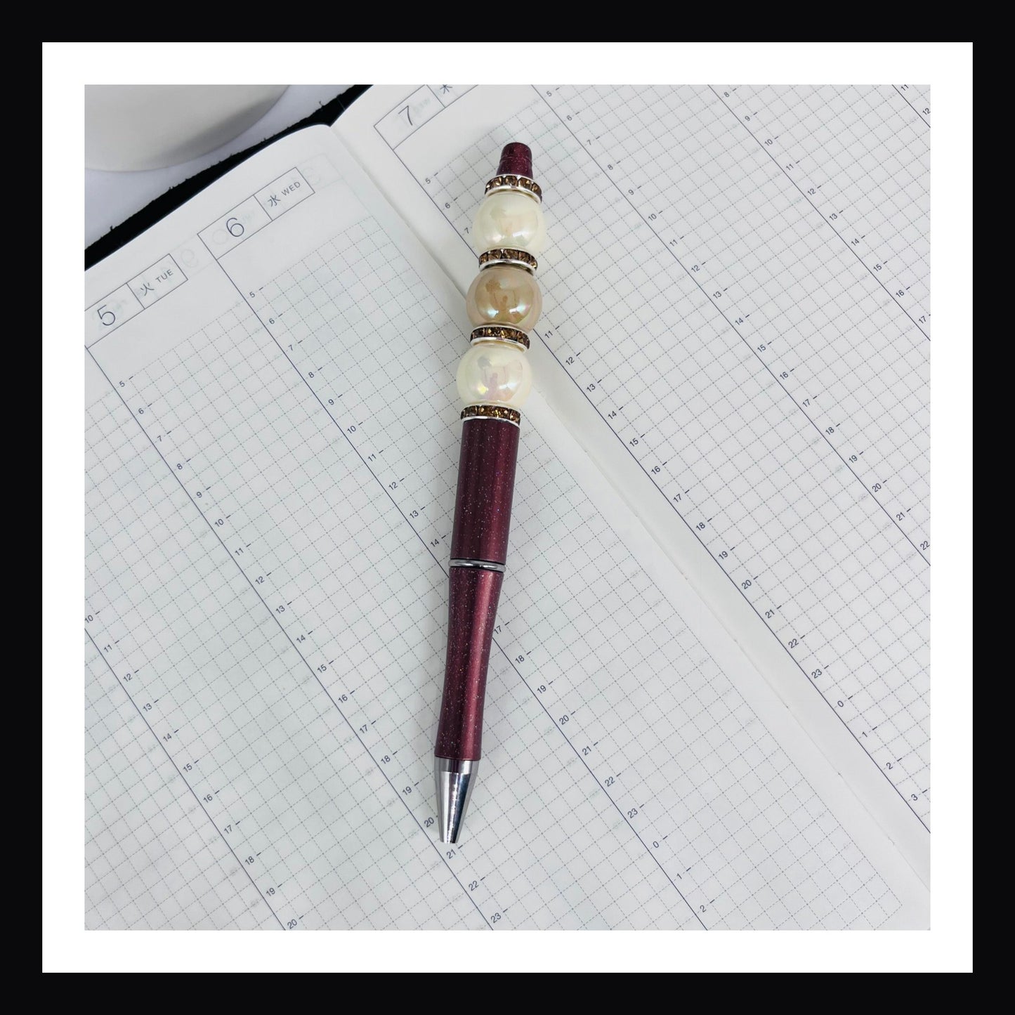 Hot Chocolate Beaded Pen is a ballpoint pen with black ink.  It features a glittery brown barrel with opalescent beads and rhinestone spacers. 