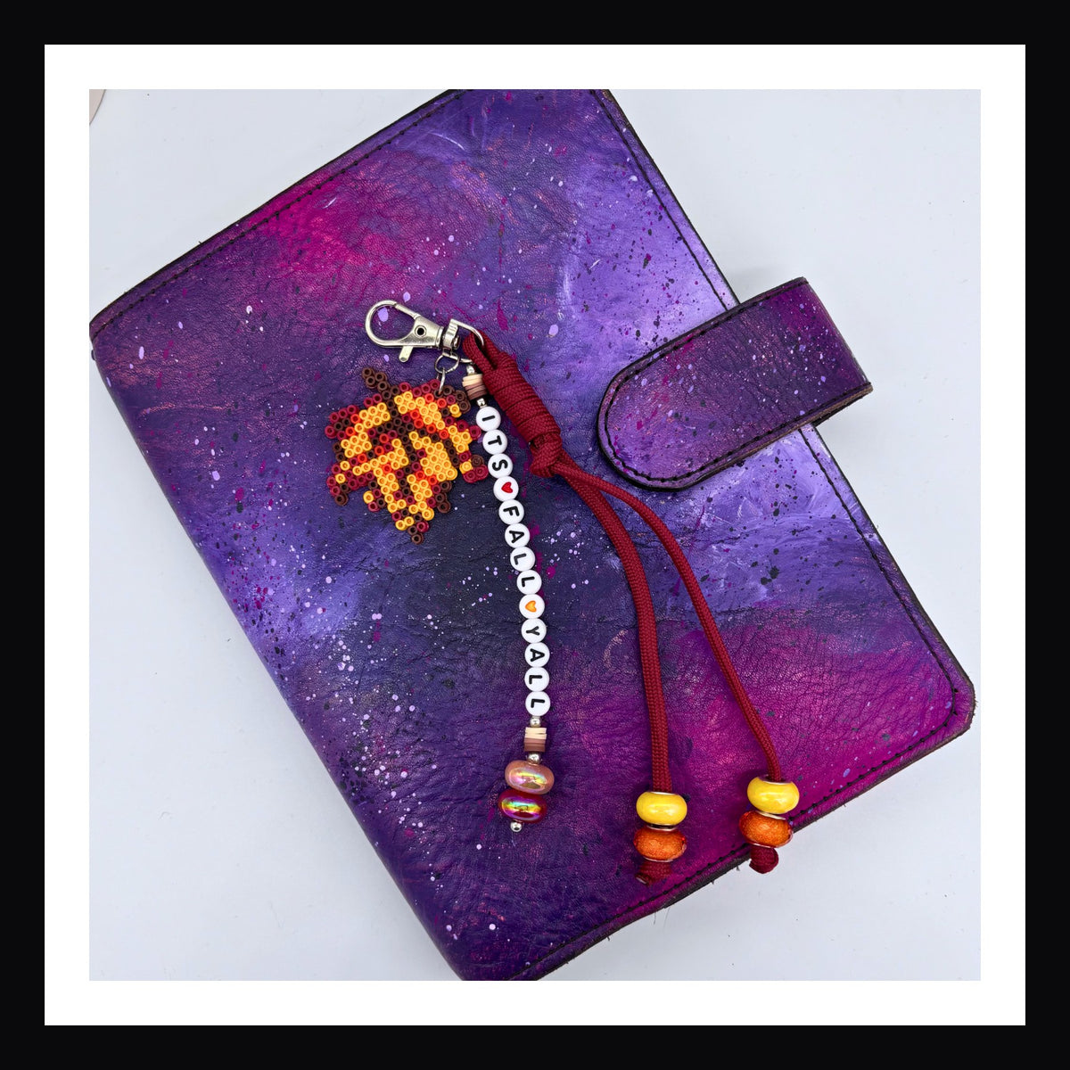 It's Fall Y'all charm features an handmade autumn leaf charm, a friendship-bracelet-style beaded tag that reads "its fall y'all" and is finished with a dark red knot made of paracord with orange and yellow beads. Attaches via a sturdy lobster clasp.