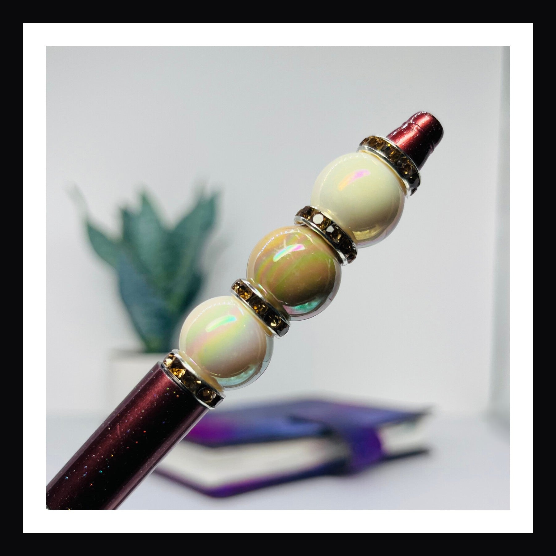 Hot Chocolate Beaded Pen is a ballpoint pen with black ink.  It features a glittery brown barrel with opalescent beads and rhinestone spacers. 