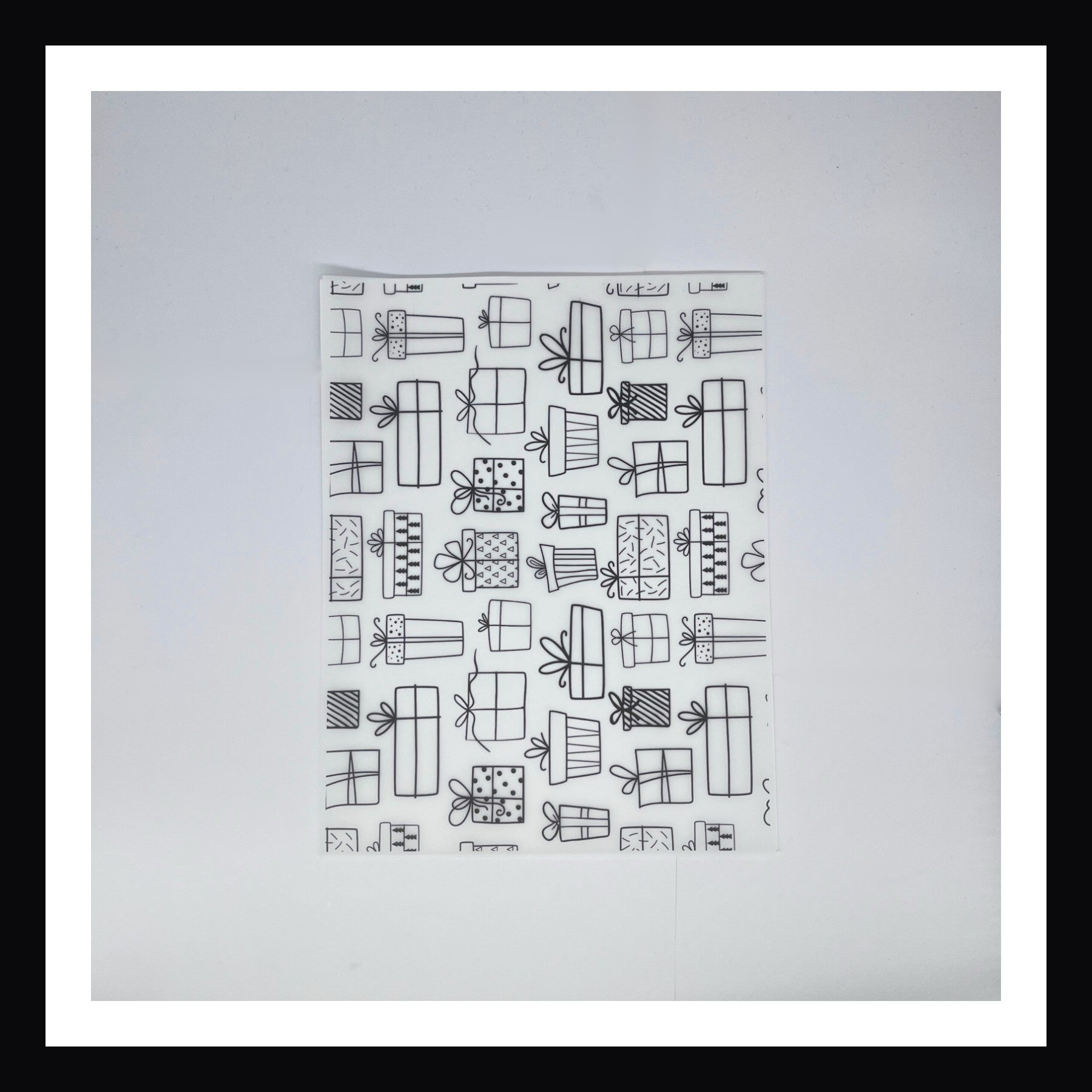 Monochromatic Christmas Vellum in Monochromatic Gifts.  An 8x10 sheet of vellum printed with a variety of doodle style holiday gifts in black & white. 