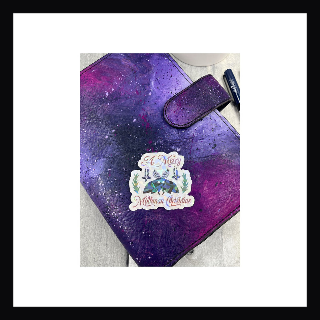 holographic die cut sticker featuring Mothman. "A merry Mothman christmas"