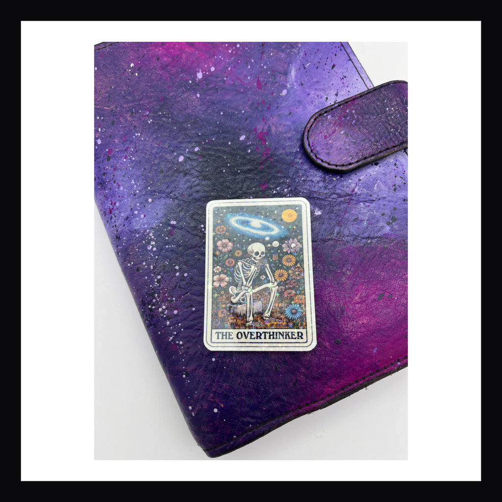 Alternative Tarot Die Cuts - The Overthinker is a holographic die cut sticker featuring a skeleton deep in thought. 