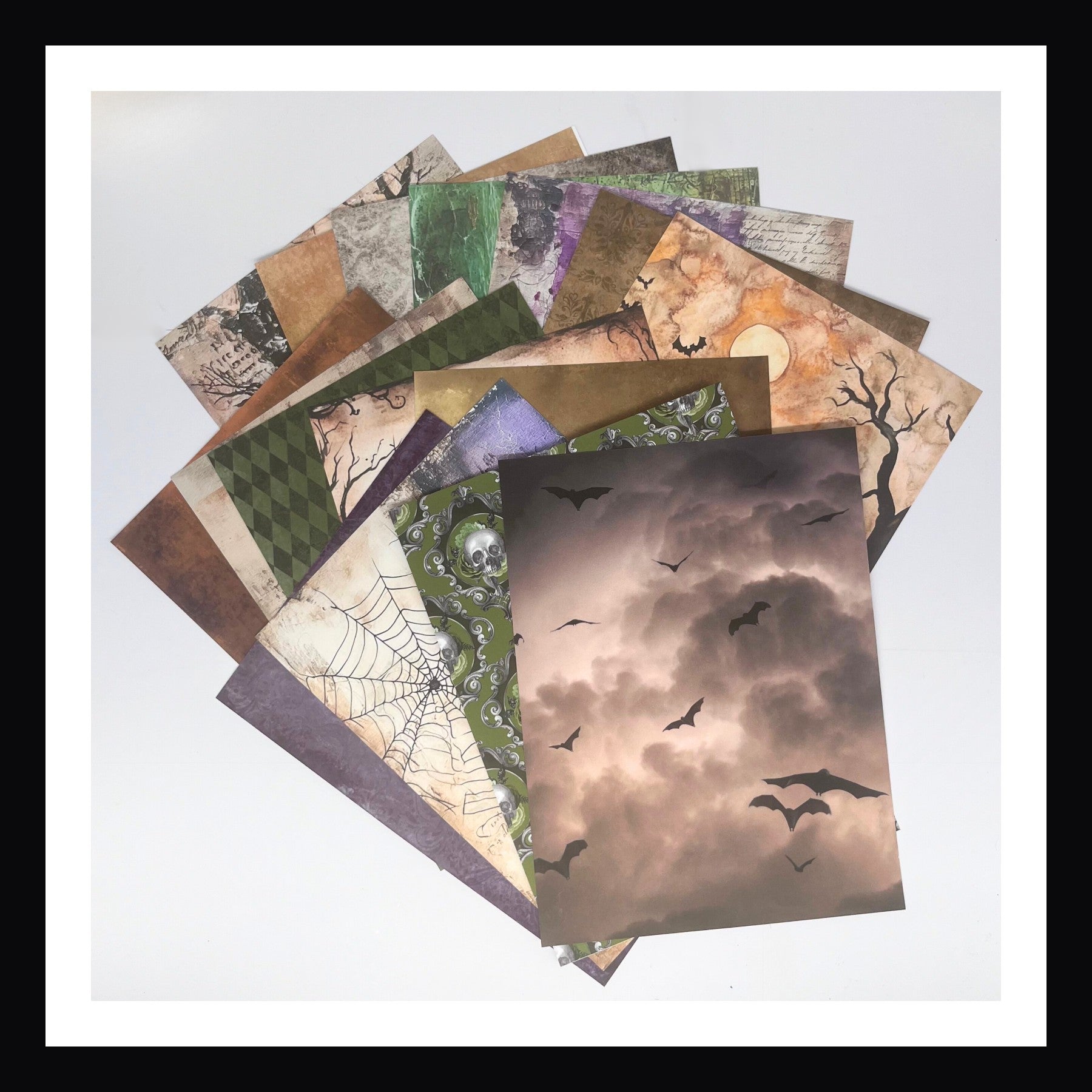Deluxe Halloween Junk Journal Kit features 16 6x8" yardstick papers.  Each paper is double sided, color palette focuses on oranges, purples, greens, greys and browns.