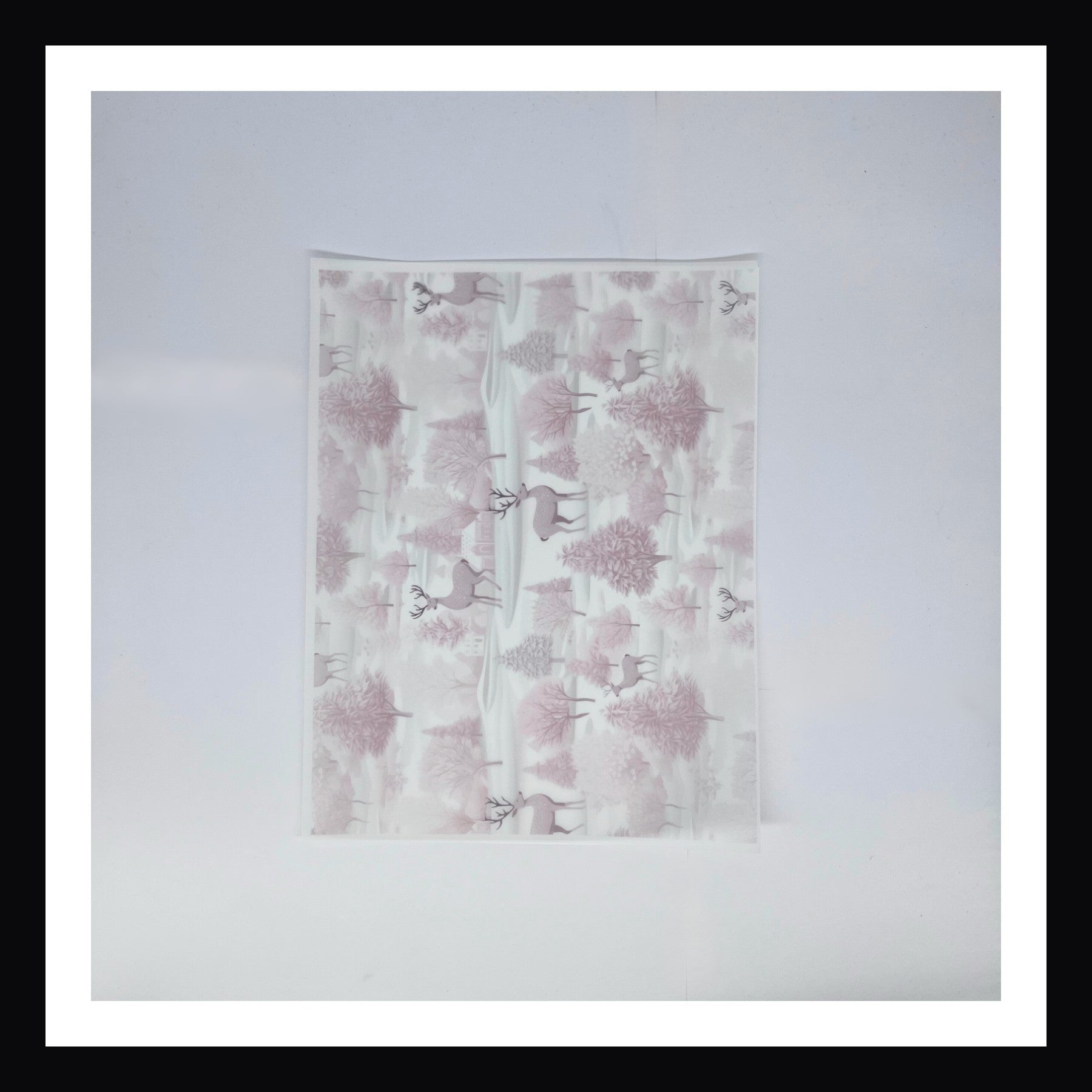 Pink Christmas Vellum - Pink Snowy Village.  A 8x10 sheet of vellum featuring a landscape of trees with homes and deer scattered throughout.  The print is done in hues of pink.