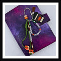 Spice Spice Baby Carabiner Bag Charm features a handmade PSL charm with pumpkin detail, a friendship-bracelet-style beaded tag reads "Pumpkin Spice Spice Baby".  Finished with a green paracord knot, vegan leather tassel and additional bead details.